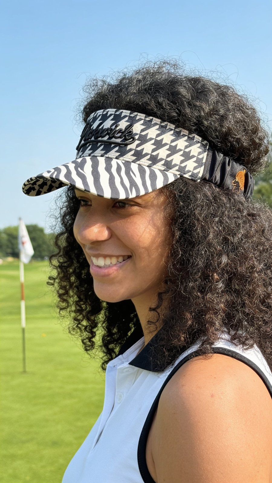 Golfer smiling in the Flexband Visor, worn over natural curls